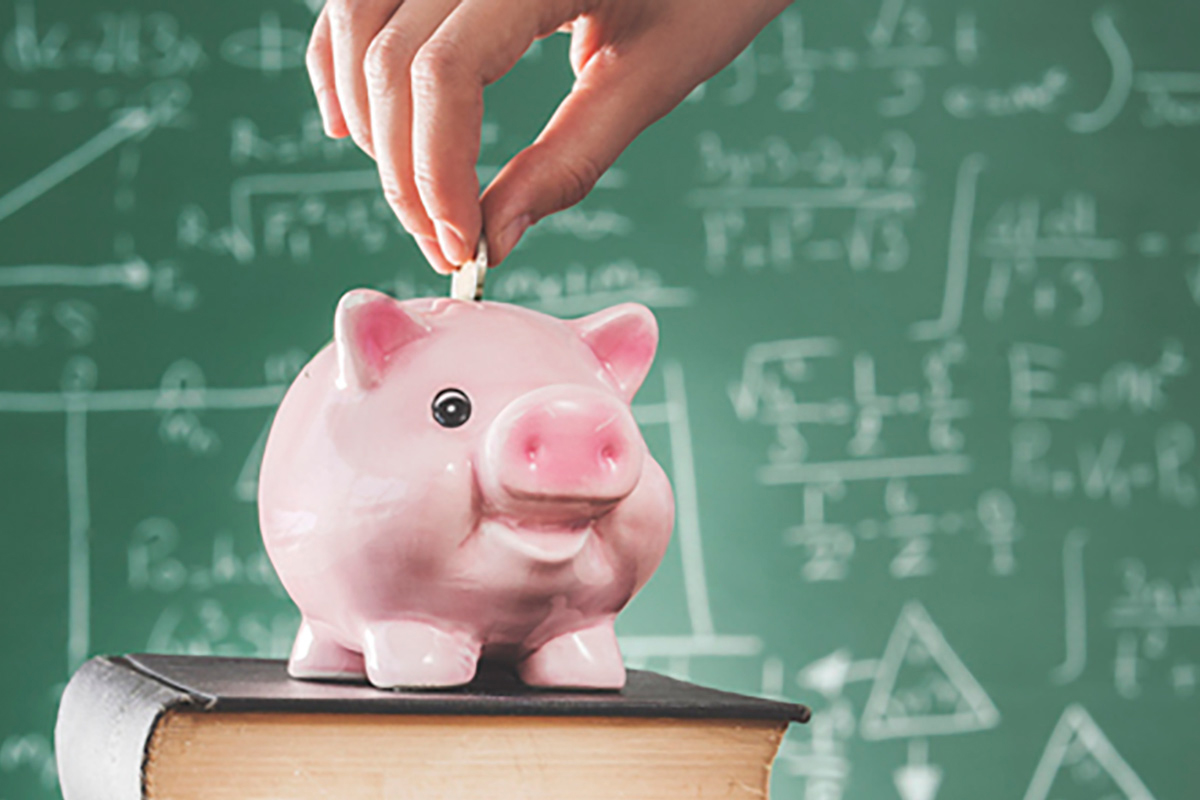 Hand placing coin in piggy bank