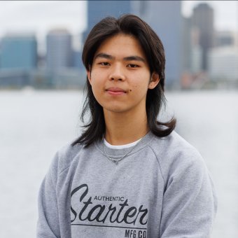 Student Sergio faces towards the camera smiling. In the background is the Perth city skyline.