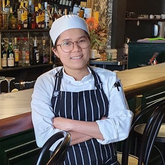 TAFE international student Socoro Pagayon in chef attire, standing in restaurant