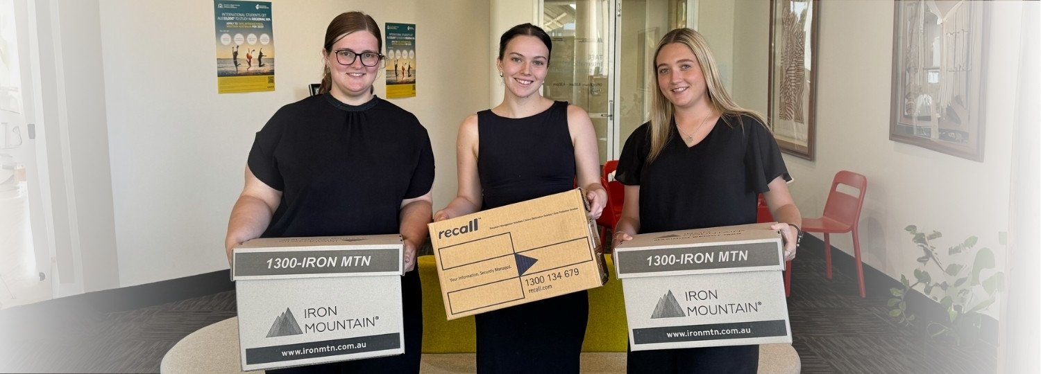 Three TIWA staff members holding moving boxes