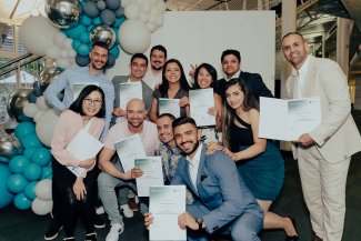 Group of TAFE international students pose with their graduation certificates