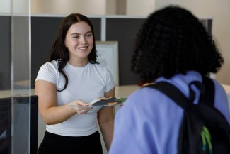 TIWA staff member handing a student a document