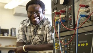 Student posing next to electrical wiring