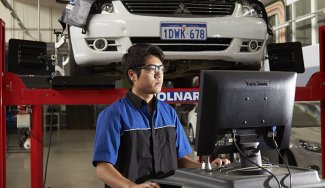 Person using a computer in an automotive workshop