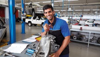 Person in an automotive workshop working on automotive equipment