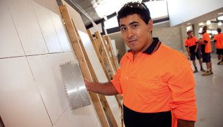 Person laying building equipment against wall