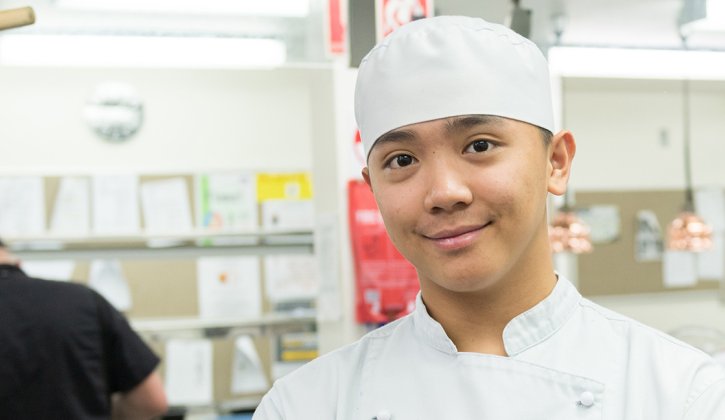 International student Deniel in chef outfit, at TAFE training kitchen facility