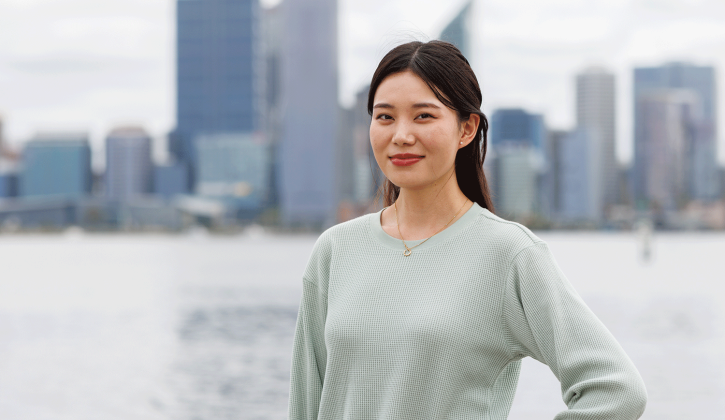Student Lhaki stands at South Perth foreshore. She's looking towards the camera smiling.