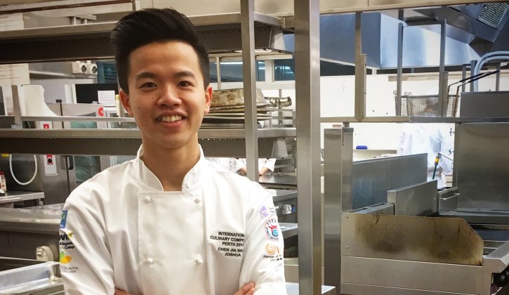 International student Josh smiling, in kitchen training facilities