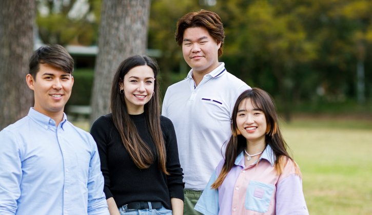 Four TAFE students on green campus grounds