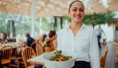 person holding food in outdoor environment