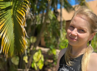TIWA student Kersti, posing on TAFE campus grounds near a palm tree